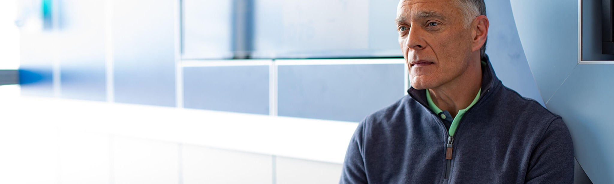 Man sitting on bench looking into distance.
