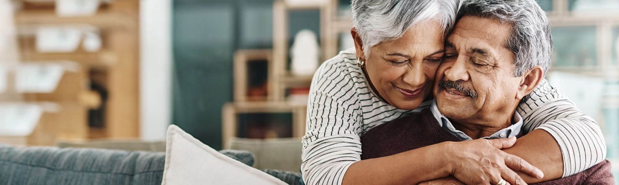 Older woman hugging older man.