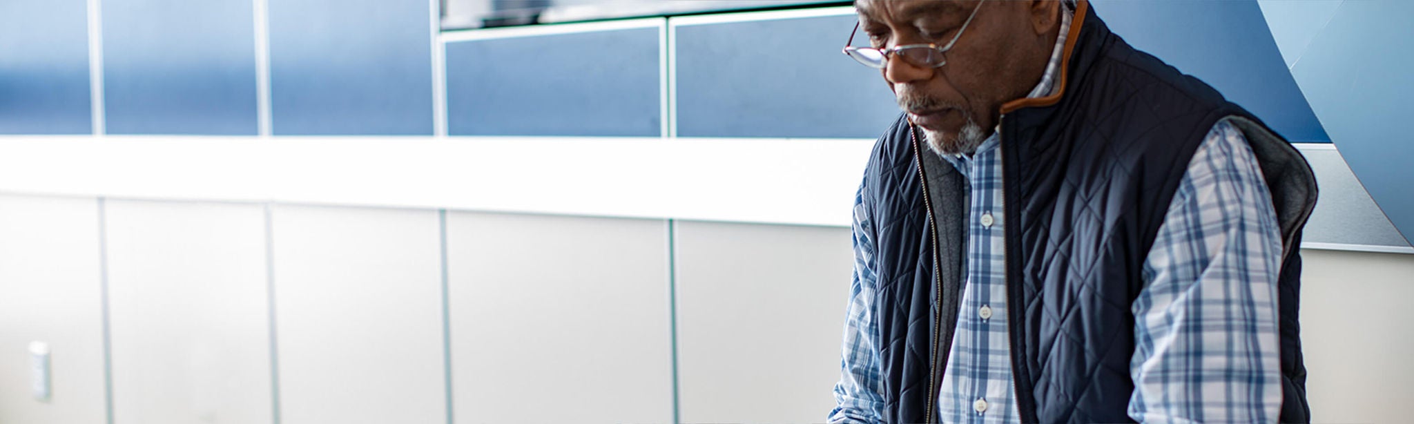 Man sitting on bench looking at a brochure.