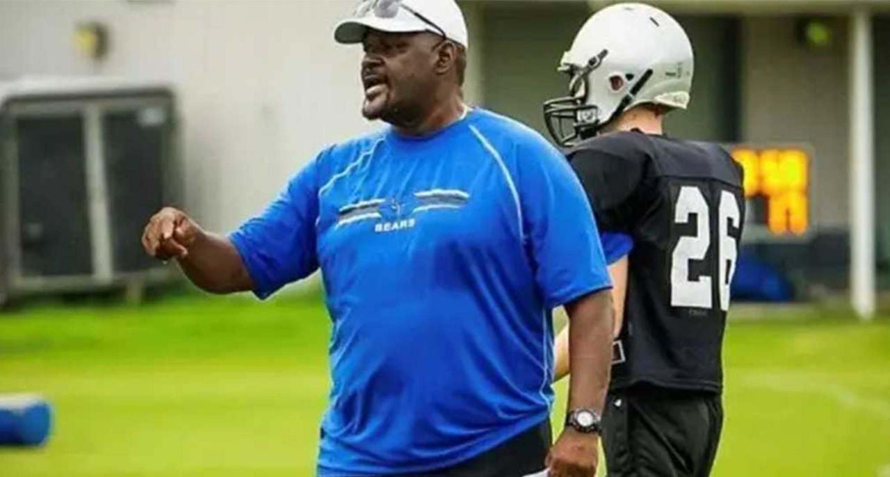 Football coach, Steve, on the field with a football player.