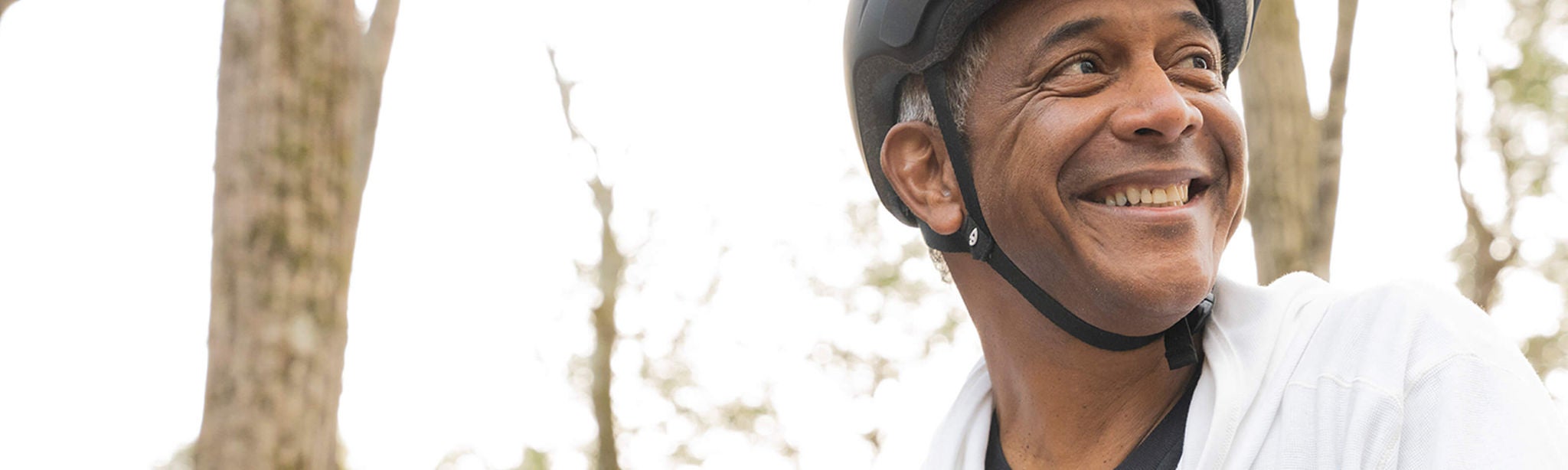 Middle-aged man wearing helmet on a bike.