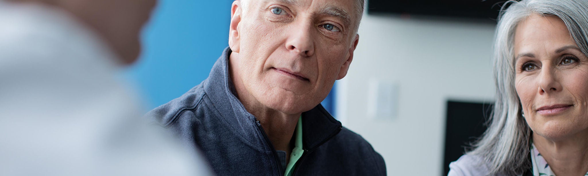 Man and woman seated listening to a physician.