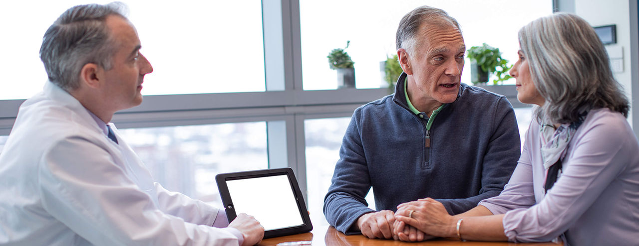 Middle-aged couple consulting with a physician.